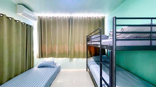 a room with two bunk beds and a window at บ้านย่าพลูวิลล่าพลาบ้านฉางระยอง in Ban Chang
