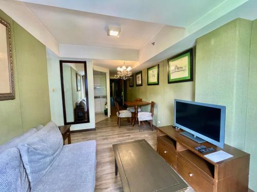 a living room with a couch and a flat screen tv at CEO Flats in Manila