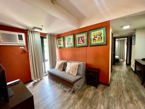 a living room with orange walls and a couch at CEO Flats in Manila