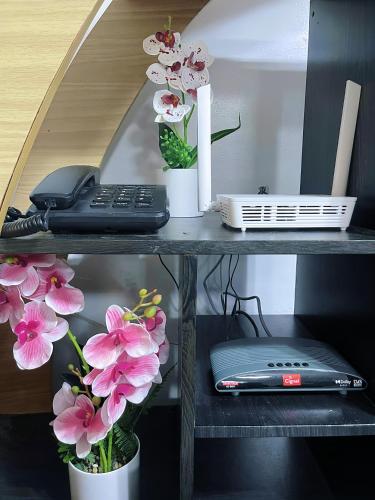 a desk with a phone and flowers on it at AB Pam Staycation Gensan up to 20 pax in Lagao III