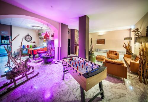 a living room with a foosball table in the middle at Das Gutenbrunn Thermen & Sporthotel in Baden