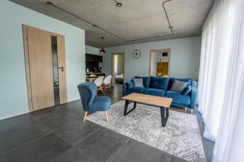 a living room with a blue couch and a table at domki Koziniec na wyłączność Myczkowce Solina Bieszczady 5 in Myczkowce