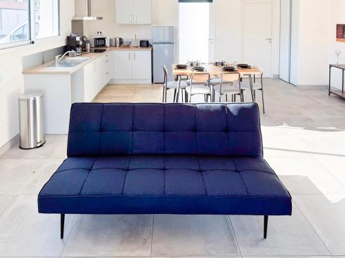 a blue couch in a kitchen with a table at Maison 2 ch-6 pers parking & jardin in La Pommeraie-sur-Sèvre