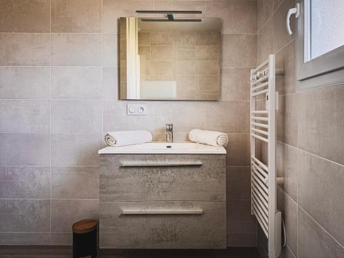 a bathroom with a sink and a mirror at Maison 2 ch-6 pers parking & jardin in La Pommeraie-sur-Sèvre