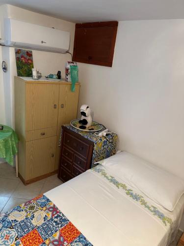a small bedroom with two beds and a table at Cottage Gole Alcantara D’amore in Graniti
