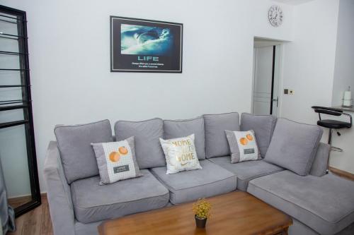 a living room with a gray couch with pillows at Modern Apt ideal for work and rest in Tatu City