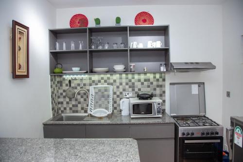 a kitchen with a counter top with a microwave at Modern Apt ideal for work and rest in Tatu City