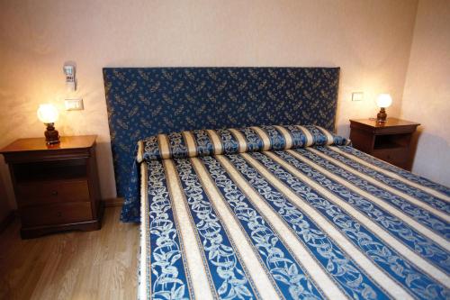 ローマにあるResidenza Matildeのベッドルーム1室(青いベッド1台、ナイトスタンド2台付)