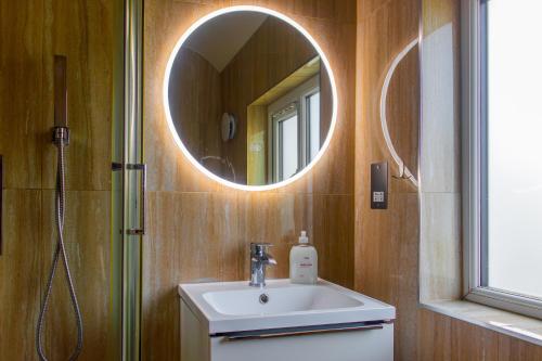 a bathroom with a sink and a mirror at Stunning Family Home nr London Harry Potter Tour Pass The Keys in Borehamwood