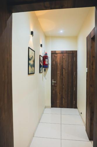 a hallway with a wooden door and a tiled floor at Ikigai Stay 3BHK Duplex in Ujjain