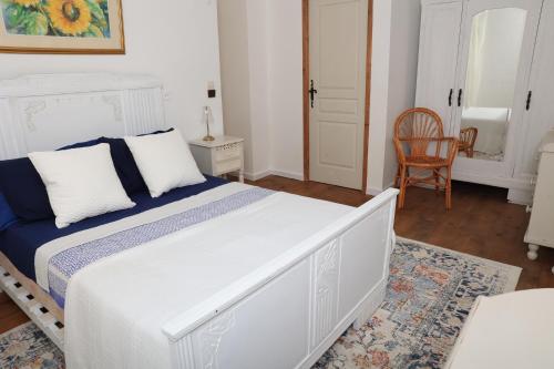 a bedroom with a white bed and a chair at Pure Gardères in Monlezun