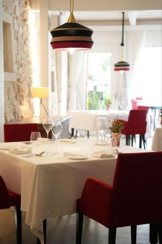 a white table with wine glasses and red chairs at Masseria Mancini in Polignano a Mare