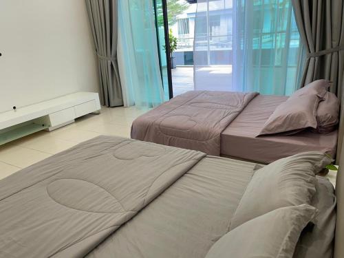 two beds in a room with a window at Dream Home Landed Balik Pulau in Balik Pulau