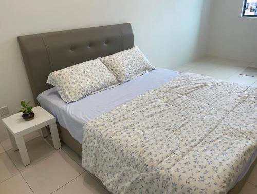 a bedroom with a bed with a pillow and a table at Dream Home Landed Balik Pulau in Balik Pulau