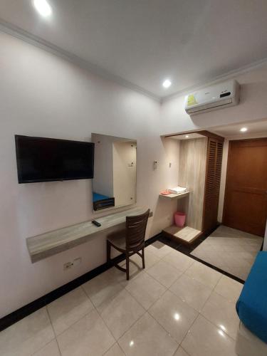 Una televisión o centro de entretenimiento en Hotel Tulip Madiun