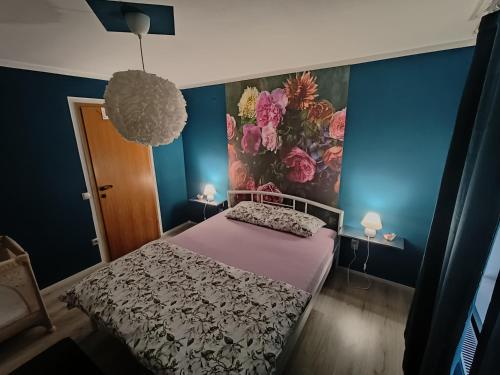 a bedroom with a bed with a floral wall at Apartment Magnolia in Blejska Dobrava