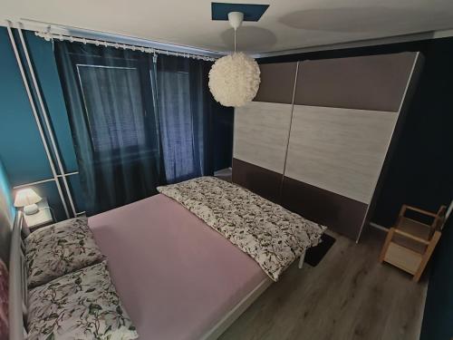 a bedroom with a bed and a cabinet and a chair at Apartment Magnolia in Blejska Dobrava