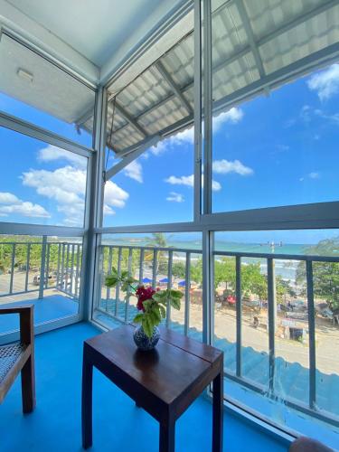 a room with a table and a view of the ocean at Seals Harbor Hotel in Weligama