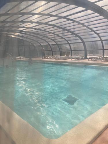 a swimming pool with blue water in a building at Mobil Home 6 personnes La Marina in Canet-en-Roussillon