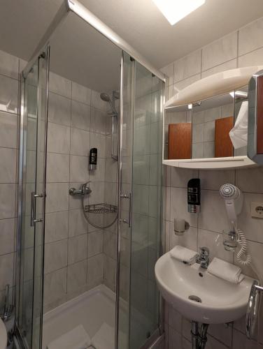 a bathroom with a shower and a sink and a shower at A - City HOTEL Schiff in Rastatt