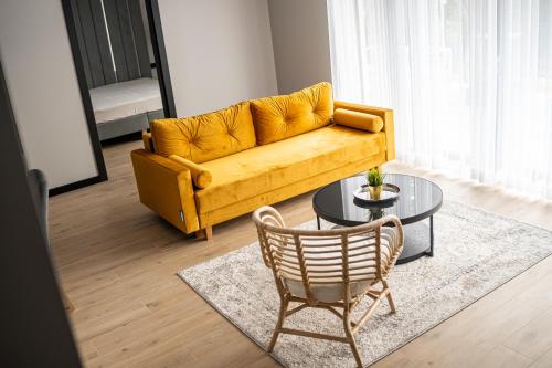 a living room with a yellow couch and a table at domki Koziniec na wyłączność Myczkowce Solina Bieszczady 5 in Myczkowce