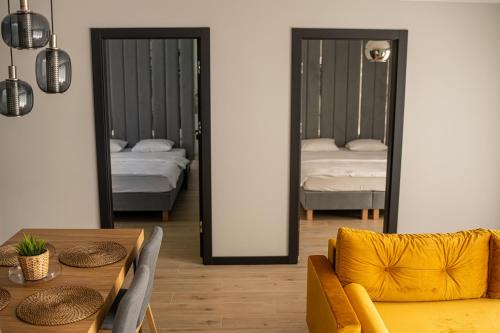 a room with two beds and a table and a mirror at domki Koziniec na wyłączność Myczkowce Solina Bieszczady 5 in Myczkowce