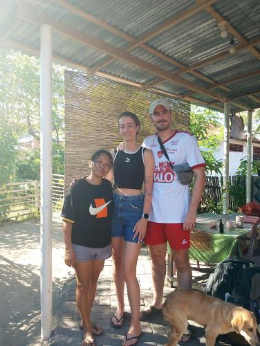 a group of people posing for a picture with a dog at Naca Homestay in Manado