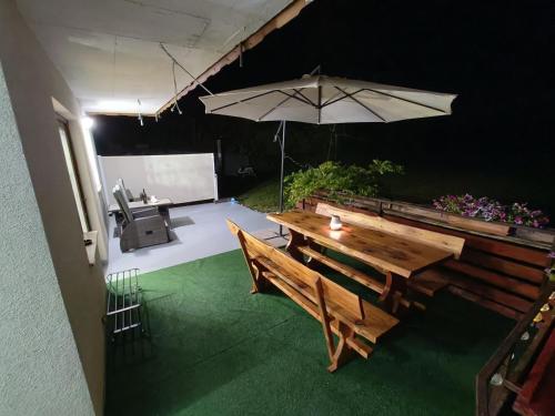 a patio with a wooden table and an umbrella at Apartment Magnolia in Blejska Dobrava