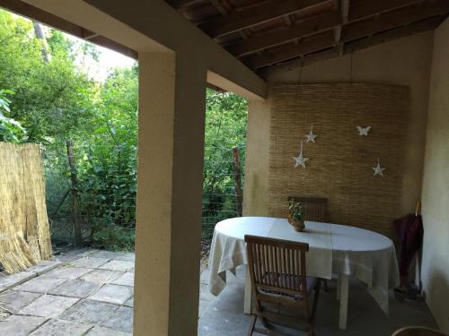 - une table sur la terrasse couverte arrière d'une maison dans l'établissement La maison de caroline, à Marcheprime