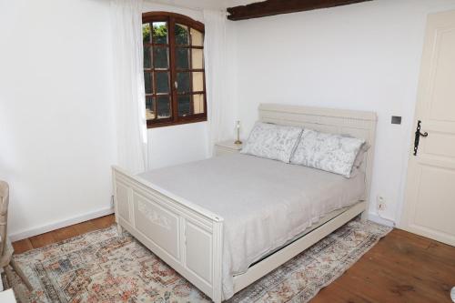 a white bed in a room with a window at Pure Gardères in Monlezun