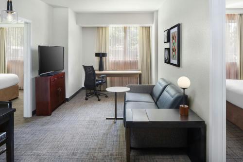 a hotel room with a couch and a television at Residence Inn by Marriott Miami Airport in Miami