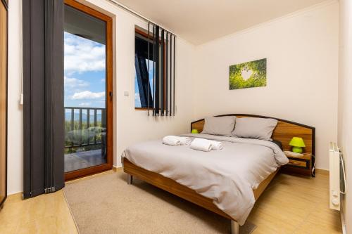 ein Schlafzimmer mit einem Bett mit zwei Handtüchern darauf in der Unterkunft Yanevi Apartments at Grand Monastery Pamporovo in Pamporowo