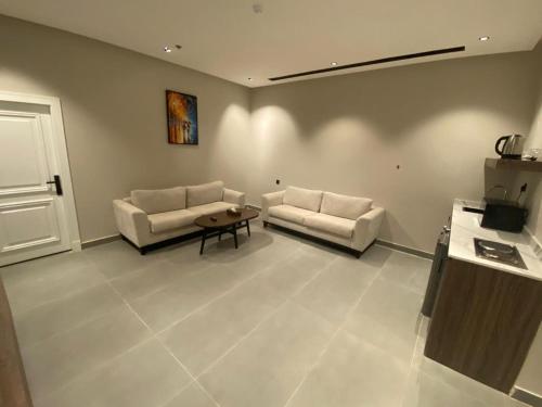 a living room with two couches and a table at شقق ثري ستار للشقق المخدومة in Al Kharj