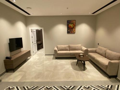 a living room with two couches and a flat screen tv at شقق ثري ستار للشقق المخدومة in Al Kharj