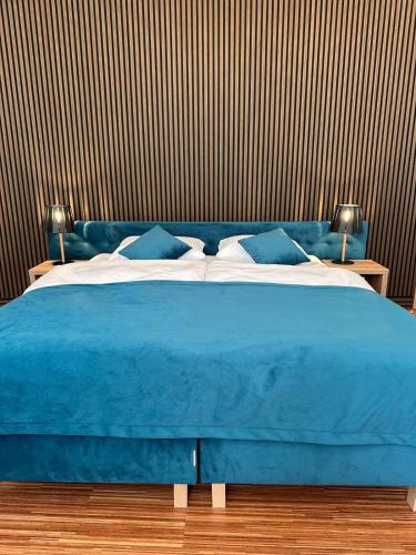 a blue bed with a blue blanket and pillows at PostersApt3-Cozy Cinema Vibes in Vienna