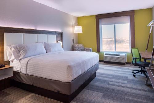 フォートワースにあるHoliday Inn Express Fort Worth West, an IHG Hotelの大きなベッドとデスクが備わるホテルルームです。