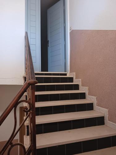 a set of stairs with a blue door at STUDIO ssud شقة in Sousse