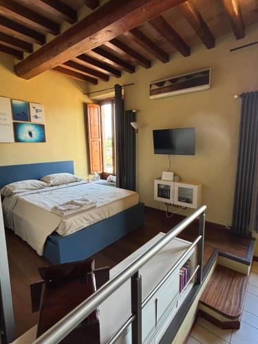 a bedroom with a bed and a television on the wall at Sweet Home Sweet Wine in Lastra a Signa