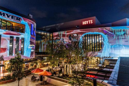 a large building with a shopping center with umbrellas at Luxury Perth CBD Apartment with Pool & Gym - Sleeps 3 in Perth