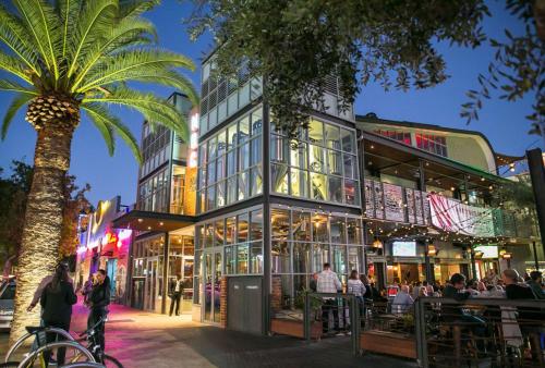 a building with a palm tree in front of it at Luxury Perth CBD Apartment with Pool & Gym - Sleeps 3 in Perth