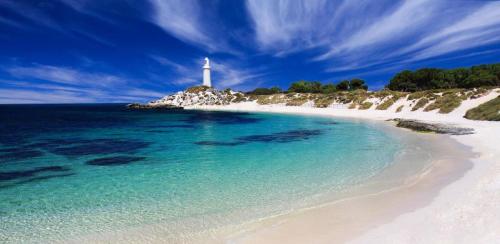 a lighthouse on a white beach with the ocean at Luxury Perth CBD Apartment with Pool & Gym - Sleeps 3 in Perth