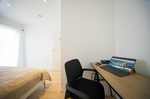 a laptop computer sitting on a desk in a bedroom at VARIO-HAUS Residence in Theresienfeld