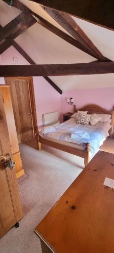 a bedroom with a bed in a attic at Brynderwen Barn in Llangorse