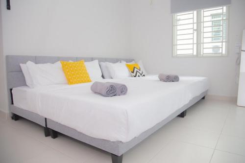 ein großes weißes Bett mit Handtüchern darüber in der Unterkunft 5min walk to Tebrau ÆON Mall 1-5pax Free Netflix in Johor Bahru