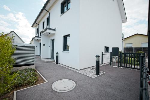 a white house with a gate and a driveway at VARIO-HAUS Residence in Theresienfeld