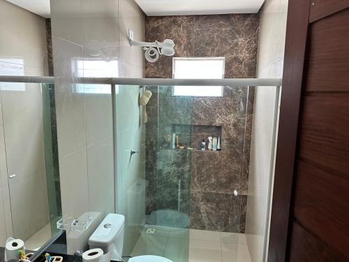 un bagno con doccia in vetro e WC di Excelente casa de praia em Paripueira 5 min do mar a Paripueira