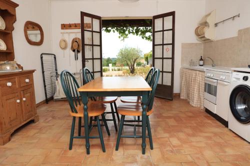 a kitchen with a wooden table and chairs at Pure Gardères in Monlezun