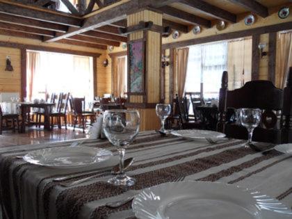 a table with plates and wine glasses on it at Готель Пацьорка in Kremintsi