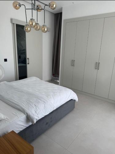 a bedroom with a bed and white cabinets and a chandelier at Mykonos Homes Villa in Aglantzia