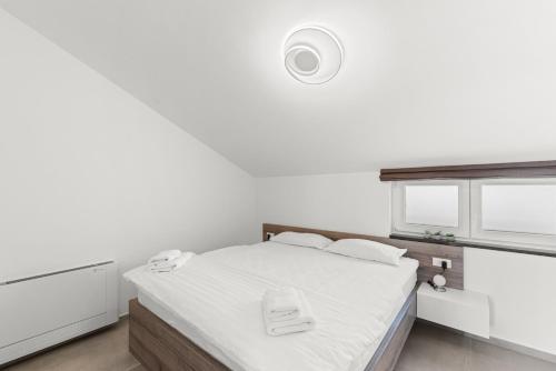 a white bedroom with a bed with white sheets at Penthouse Stella Marini with jacuzzi and sea view 2,5 km from sea in Tar